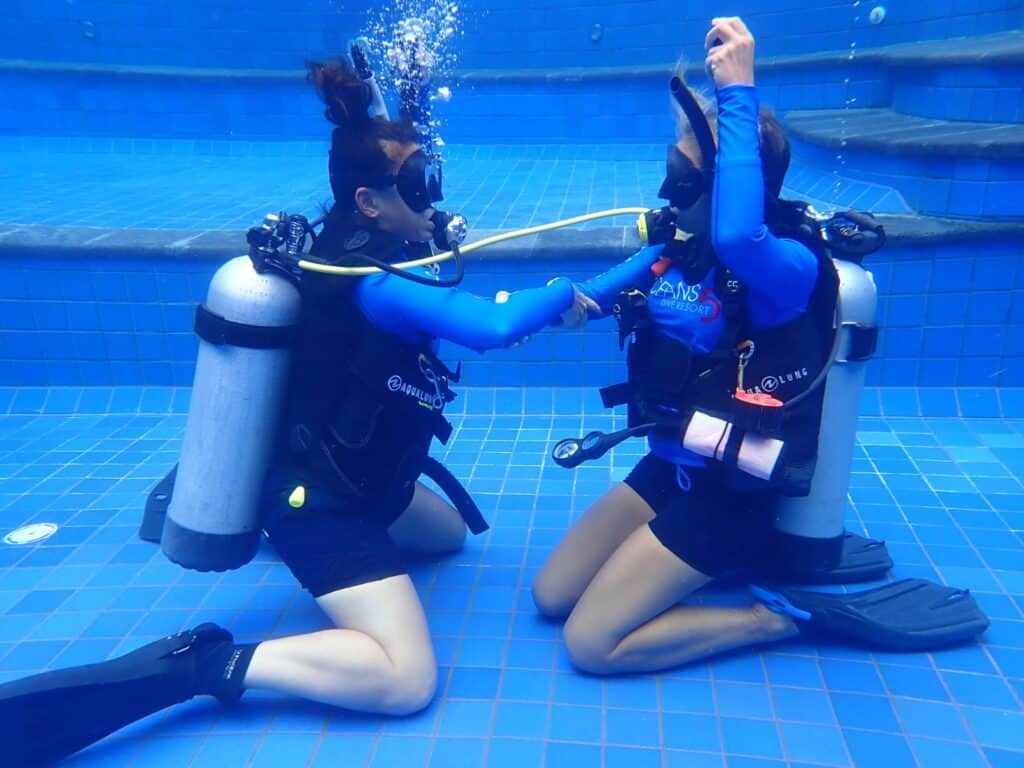 Scuba diving instructors conducting confined water training while maintaining safety standards